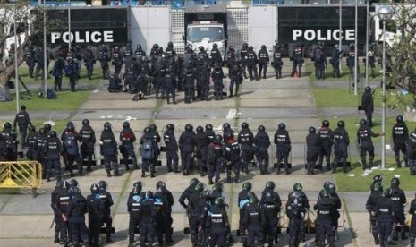 Riot policemen stand guard during clash with anti-government protesters at the Thai-Japan youth stadium in central Bangkok December 26, 2013.