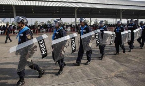 Riot policemen walk around during a registration of election candidates at a bus terminal centre near the Government complex in Bangkok December 28, 2013.