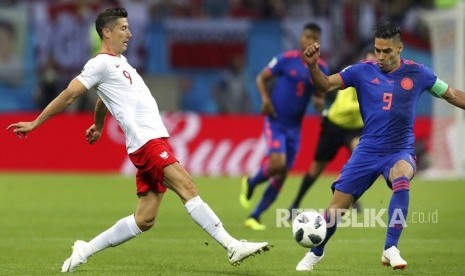  Robert Lewandowski dan Radamel Falcao berebut bola pada pertandingan grup H Piala Dunia 2018 antara Polandia dan Kolombia di Kazan Arena di Kazan, Rusia, Ahad (24/6). 