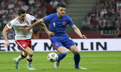 Robert Lewandowski dari Polandia berebut bola dengan Declan Rice dari Inggris, kanan, selama pertandingan sepak bola kualifikasi grup I Piala Dunia 2022 antara Polandia dan Inggris, di stadion Narodowy di Warsawa, Rabu, 8 September 2021.