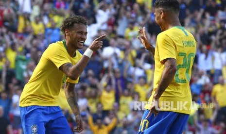 Roberto Firmino  melakukan selebrasi dengan rekan setimnya Neymar setelah mencetak gol kedua timnya pada laga persahabatan antara Brasil dan Kroasia di Stadion Anfield di Liverpool,  Inggris, Ahad (3/6).