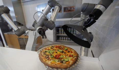 Robot pembuat pizza memamerkan kemampuannya di Montevrain, dekat Paris, Prancis, 26 Juni 2018.