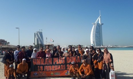 Rombongan jamaah umrah plus Dubai NRA Group berfoto bersama dengan latar belakang gedung pencakar langit di Dubai.