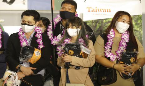 Rombongan pertama wisatawan asing memegang suvenir setelah tiba di Bandara Internasional Taoyuan di Taoyuan, Taiwan Utara, Kamis 13 Oktober 2022. Taiwan mengumumkan akan mengakhiri karantina wajib COVID-19 bagi orang yang datang dari luar negeri mulai 13 Oktober. Pusat Komando Epidemi mengumumkan bahwa persyaratan selama seminggu sebelumnya akan diganti dengan periode pemantauan mandiri tujuh hari.