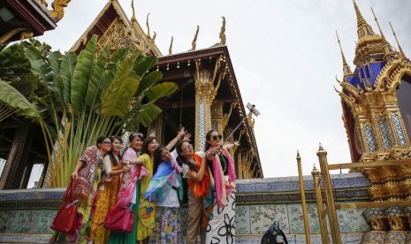 Rombongan turis berpose dengan latar Grand Palace di Bangkok, Thailand (ilustrasi). Thailand mulai membuka pariwisata untuk turis yang telah divaksinasi dari 60 negara.