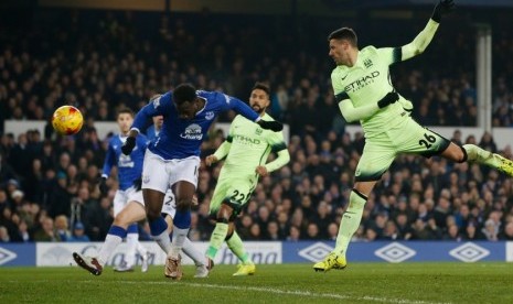 Romelu Lukaku (biru) menanduk bola untuk menjebol gawang Manchester City.