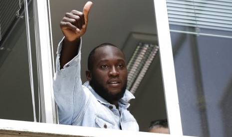 Romelu Lukaku mengacungan jempol ketika ia memberi hormat kepada pendukung Inter Milan dari jendela markas Komite Olimpiade Italia, di Milan, Italia, Kamis (8/8/2019).