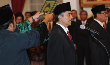 Roy Suryo (central) takes an oath at the State palace in Jakarta on Tuesday. He is inaugurated as Minister of Youh and Sports.  