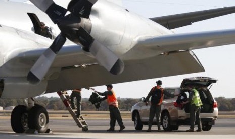 Royal Australian Air Force (RAAF) AP-3C Orion crew members unload equipment after returning from a search for Malaysian Airlines flight MH370 over the Indian Ocean, at RAAF Base Pearce north of Perth, Australia, March 21, 2014.