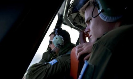 Royal Australian Air Force (RAAF) pilot Flight Lieutenant Joshua Williams (left) and Flying Officer Daniel Bailey look from the cockpit of an RAAF AP-3C Orion aircraft.