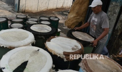 Rudi seorang pedagang beduk sedang merapihkan beduk jualannya di kisaran jalan KH Mas Mansyur Jakarta, Senin (12/6). 