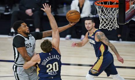 Rudy Gay dari San Antonio Spurs (kiri) melewati Nicolo Melli dari New Orleans Pelicans (20) untuk melepaskan lay updalam pertandingan bola basket NBA, di Lake Buena Vista, Florida, AS, Ahad (9/8).