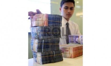  Rupiah Semakin Melemah: Teller melakukan transaksi dengan nasabah di Banking Hall Bank Mandiri, Jakarta, Rabu (11/3). 