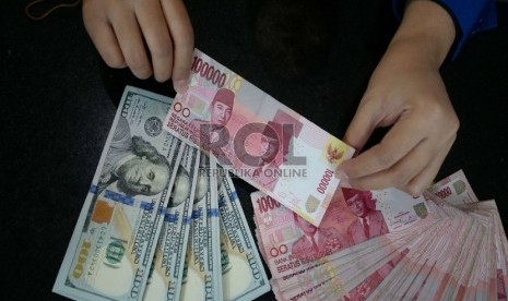 Rupiah Terus Merosot: Petugas menghitung uang rupiah dan dolar di salah satu penukaran uang di Jakarta, Kamis (5/3).