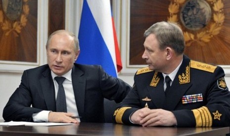 Russian President Vladimir Putin, left, and Russian Navy's commander-in-chief Viktor Chirkov, right, talk on board a navy ship in Severomorsk, Russia, on Thursday, Jan. 10, 2013.   