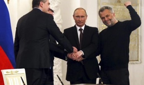 Russian President Vladimir Putin (second right), Crimea's Prime Minister Sergei Aksyonov (front left), Crimean parliamentary speaker Vladimir Konstantinov (back left) and Sevastopol Mayor Alexei Chaliy shake hands after a signing ceremony at the Kremlin in