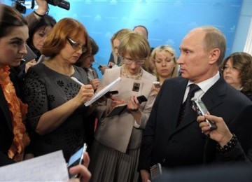 Russian Prime Minister Vladimir Putin, right, speaks during a meeting with reporters in Moscow, recently. 