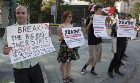 Russian supporters of NSA leaker Edward Snowden rally with posters protesting total surveillance in Moscow, Russia, Friday, July 12, 2013. 