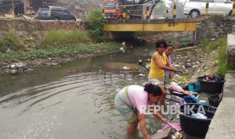 Rutinitas ibu-ibu mencuci di kali tepat di samping jalan raya, di tengah keterbatasan air bersih, Desa Teluk Naga, Kabupaten Tangerang, Rabu (8/8).