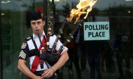 Ryan Randall plays the bagpipes outside a polling station in Edinburgh, Scotland September 18, 2014.