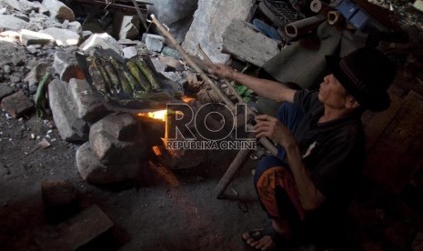 Saib (60) memasak menggunakan kayu bakar di rumahnya di kawasan Penjaringan, Jakarta Utara, Senin (18/8). (Republika/Rakhmawaty La'lang)