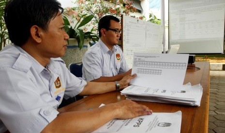 Saksi salah satu pasangan Cagub-Cawagub mengecek data hasil pemilih di Kel Kebon Sereh, Jakarta Pusat, Kamis (12/7). Panitia Pemungutan Suara (PPS) di tingkat Kelurahan mulai melakukan rekapitulasi suara serentak pada hari ini, menurut Ketua Pokja Sosialis