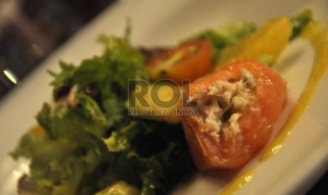 Salad dedauan hijau dengan potongan ikan salmon.