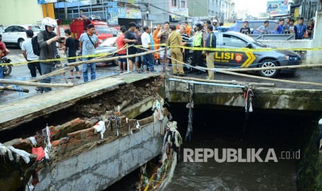 Salah satu bagian trotoar tinggal setengahnya akibat tergerus arus sungai, di Jl Pagarsih, Kota Bandung, Senin (24/10). Di lokasi tersebut satu buah motor dan mobil terbawa arus sungai dan belum ditemukan. (Republika/Edi Yusuf)