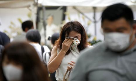 Salah satu orang yang mempersembahkan bunga dan doa untuk mantan Perdana Menteri Shinzo Abe, menangis di kuil Zojoji di Tokyo Selasa, 12 Juli 2022. Abe dibunuh Jumat saat berkampanye di Nara, Jepang barat.