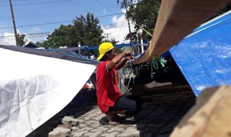 Salah satu pengungsi di Masjid Raya Baiturrahim, Palu, Sulawesi Tengah, Muhammad Nasir (34), tengah mereparasi tenda pengungsiannya, Ahad (14/10). 