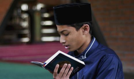 Salah satu santri Pondok Pesantren Tahfidz & Enterpreneur Thursina YBM PLN tengah membaca Alquran.