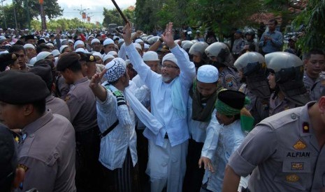   Salah satu tokoh Ulama Madura, menenangkan massa saat akan berusaha menerobos blokade Polisi, usai mengikuti istighasah terkait pengungsi Syiah, di Sampang, Jatim, Kamis (20/6).    (Antara/Saiful Bahri)