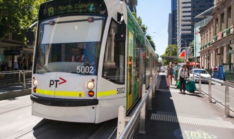 Salah satu trem di kota Melbourne sedang berhenti di Elizabeth Street. 