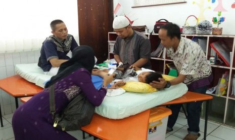 Salah seorang anak tengah dikhitan oleh dokter di SD Bina Insani Bogor,  Sabtu (24/10).