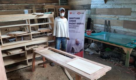 Salah seorang penerima manfaat projek padat karya UMKM Bank HSBC, saat didatangi relawan, Solikun sedang mengerjakan lemari pesanan dari pelanggannya, Kamis (14/10).