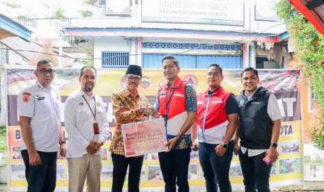 Sales Area Manager (SAM) Pertamina Sumbar Narotama Aulia Fazri , saat menyerahkan bantuan uang tunai yang diterima Bupati Limapuluh Kota Safaruddin Dt Bandaro Rajo di Posko BPBD Limapuluh Kota, Pusat Kota Payakumbuh