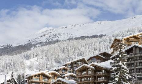 Salju menutupi atap-atap dan pepohonan di kawasan Zermatt, Swiss, di awal tahun 2018.