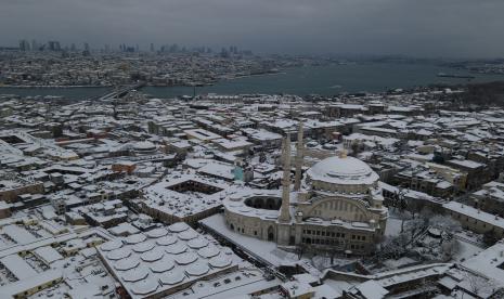 Salju menutupi atap dan masjid Nuruosmaniye (kanan) setelah hujan salju lebat di Istanbul, Turki, Selasa (25/1/2022). Tim penyelamat di Istanbul dan Athena pada Selasa membersihkan jalan yang macet setelah cuaca dingin dan badai salju besar-besaran melanda sebagian besar Turki dan Yunani, menyebabkan banyak orang dan kendaraan di kedua kota terdampar semalaman dalam kondisi beku.