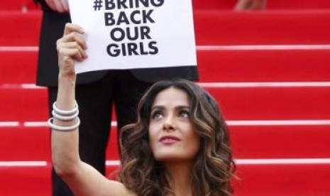 Salma Hayek memegang poster meminta Boko Haram mengembalikan korban penculikan di Nigeria.