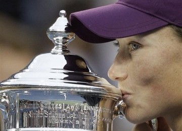 Samantha Stosur mencium trofi usai mengalahkan Serena Williams di final Amerika Terbuka 2011, di New York, Ahad (11/9). AP/Matt Slocum