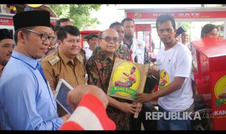 Ketua BAZNAS RI,  Bambang Sudibyo menerima kipas angin Kang Sate saat meresmikan lembaga Pemberdayaan Ekonomi Mustahik (LPEM) meresmikan kelompok usaha sate yang diberi nama Gartim Setia Rasa di Kecamatan Cabangbungin, Kabupaten Bekasi, Senin (17/2). 