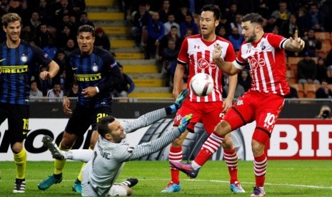 Samir Handanovic (bawah) menjatuhkan badan untuk mencegah bola masuk ke gawangnya.