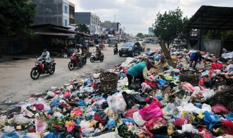 Sampah menumpuk memenuhi badan jalan di Jalan Rajawali, Kota Pekanbaru, Selasa (7/6). Tumpukan sampah kini banyak ditemukan di sudut Kota Pekanbaru setelah upaya pemerintah daerah untuk menswastanisasi layanan angkut sampah melalui PT Multi Inti Guna (MIG)