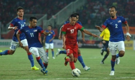 Samsul Arif dijaga para pemain Malaysia dalam laga uji coba di Stadion Gelora Delta Sidoarjo, Ahad (14/9).