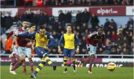 Santi Cazorla saat mencetak gol ke gawang West Ham United lewat tendangan penalti, Ahad (28/12).