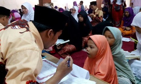 Santri cilik tengah menyetor hafalan dalam seleksi wisuda akbar. 