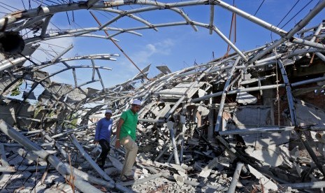 Santri melintas diantara puing kubah masjid Pasantren modern Mahadal Ulum Dinah Islamiyah (MUDI) yang runtuh akibat gempa di Samalanga, Kabupaten Bireuen, Aceh, Kamis (8/12). 