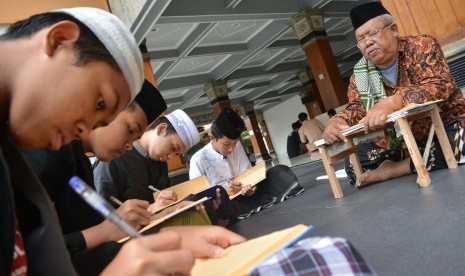 Santri memaknai kitab kuning di masjid Pesantren Tebuireng Jombang, Jawa Timur, Ahad (17/2/2019).