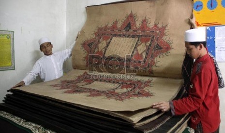  Santri membuka lembaran Alquran terbesar di Masjid Thoha Pondok Pesantren Al-Ashriyah Nurul Iman, Parung, Bogor. (Ilustrasi)   (Republika/ Yasin Habibi)