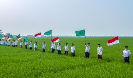 Santri mengibarkan bendera Merah Putih dan Nahdlatul Ulama saat mengikuti kirab santri di Desa Ciwulan, Telagasari, Karawang, Jawa Barat.